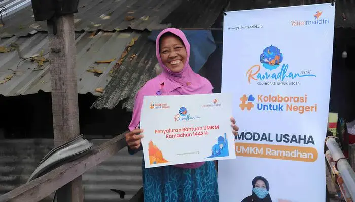 Seorang Ibu Tersenyum Mendapatkan Bantuan dari Program UMKM Ramadhan